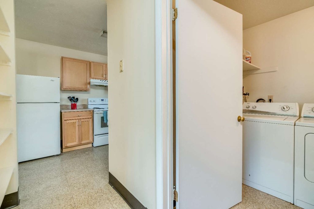 a kitchen with white appliances and a white door