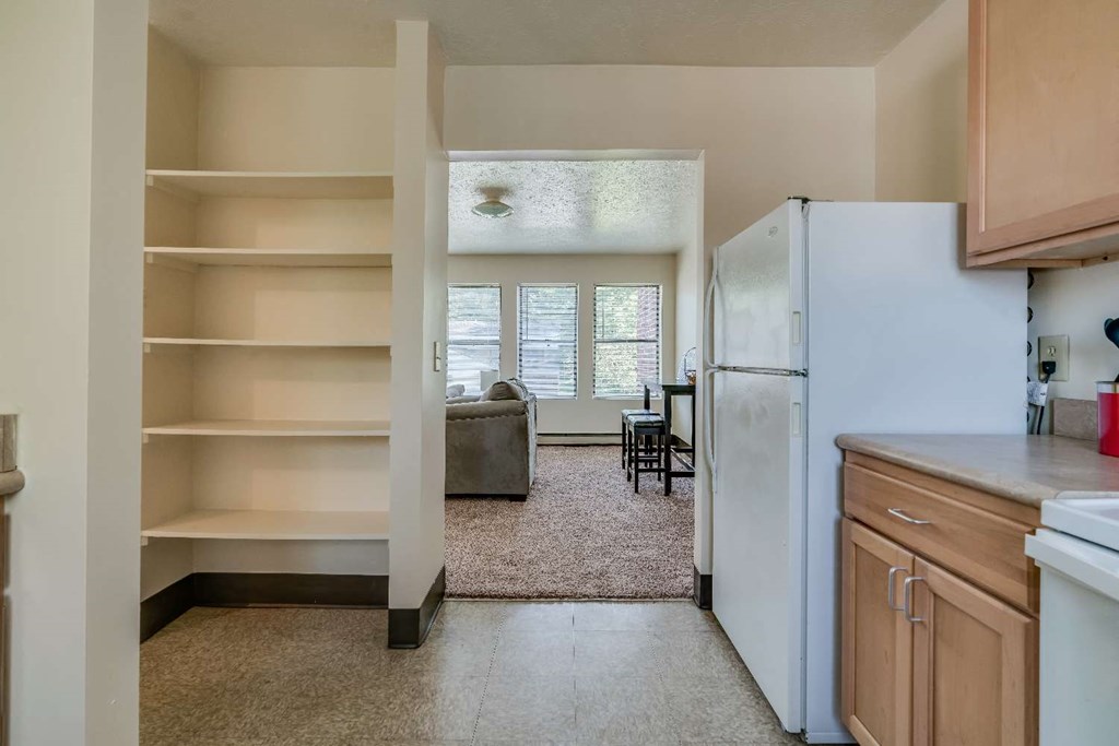 a kitchen with a refrigerator and a view of a living room