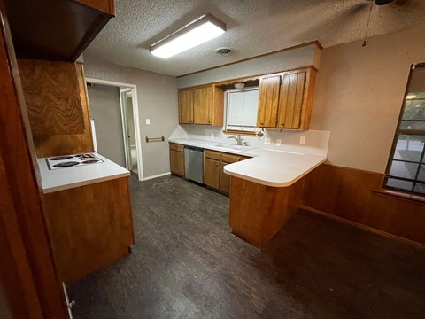 A kitchen with wooden cabinets and a white countertop.