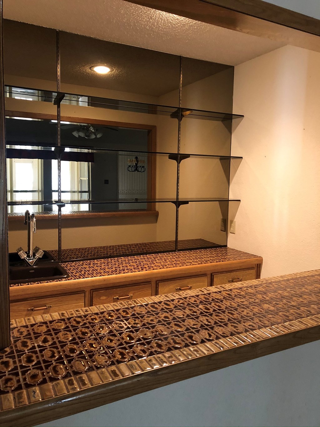 a kitchen counter with a sink and a mirror