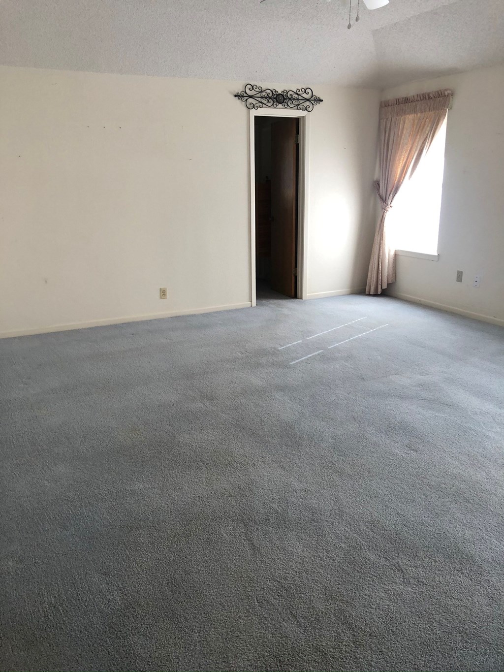 an empty living room with a carpeted floor and a door