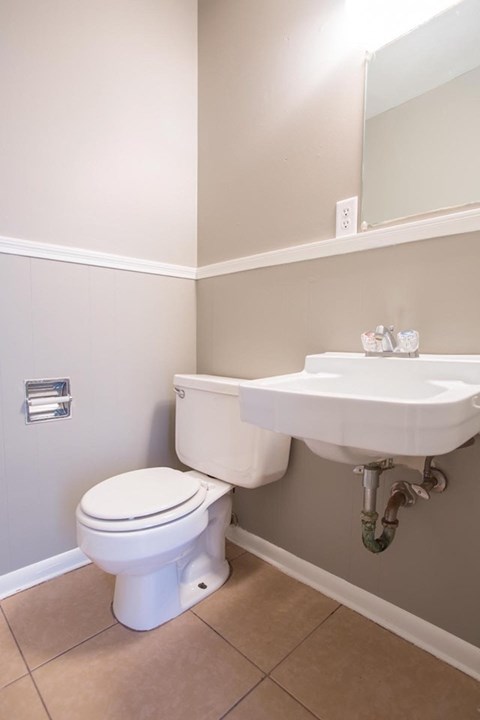 A white toilet sits next to a sink in a bathroom.