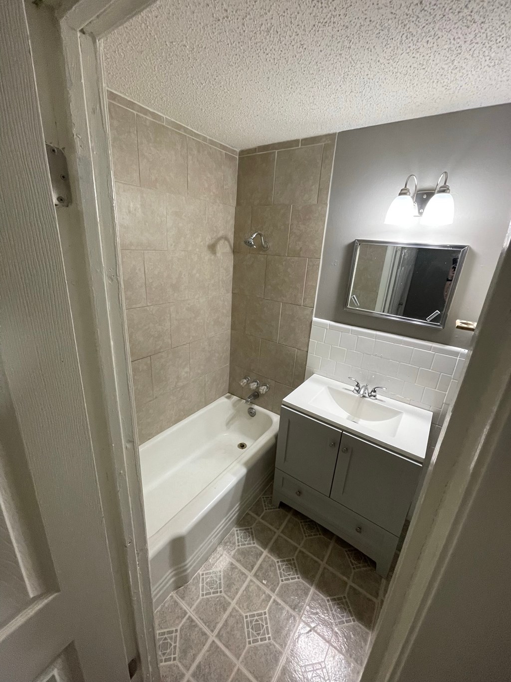 a small bathroom with a tub sink and mirror