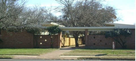 a house with a covered porch and a brick wall