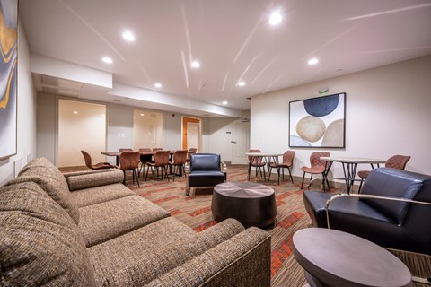 a living room with couches and chairs and a table with chairs