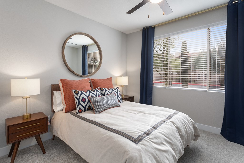 a bedroom with a large window and a bed with pillows