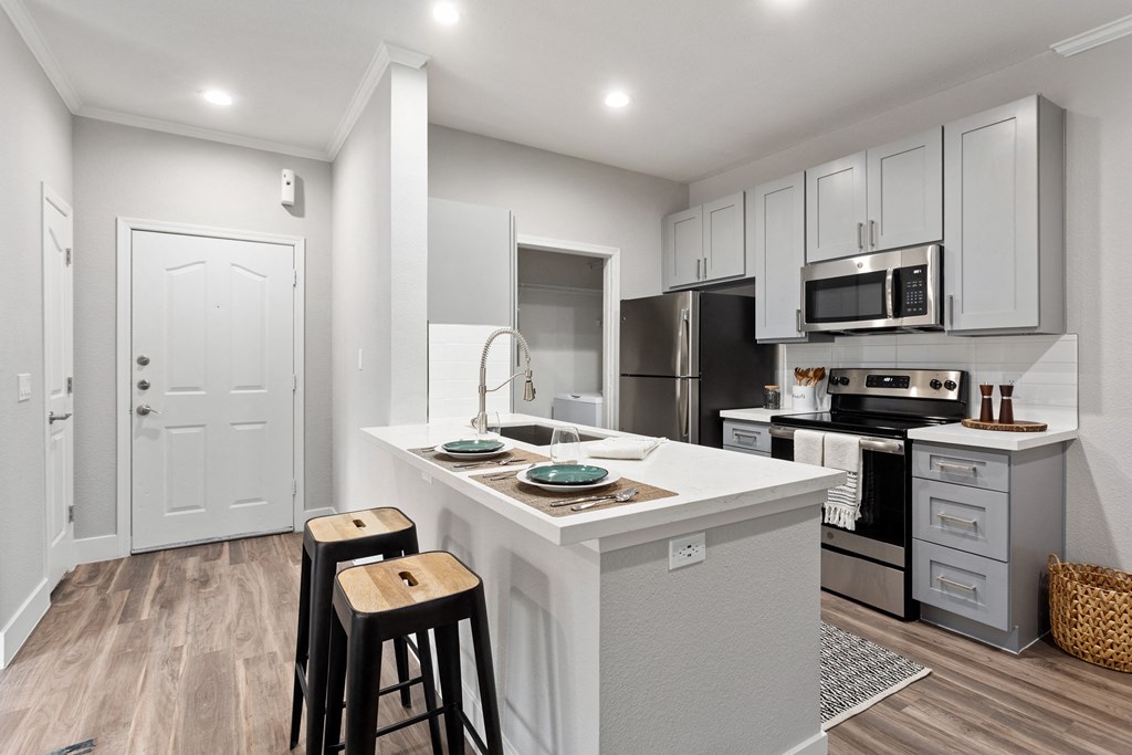 an open kitchen with a large island with two stools