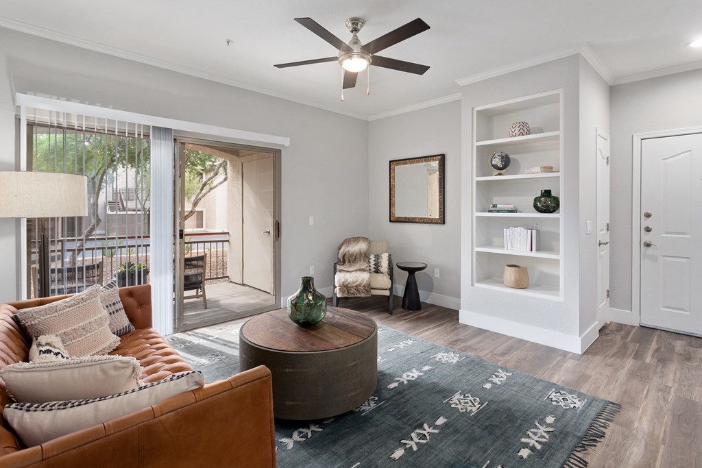 an open living room with a ceiling fan and a door to a balcony