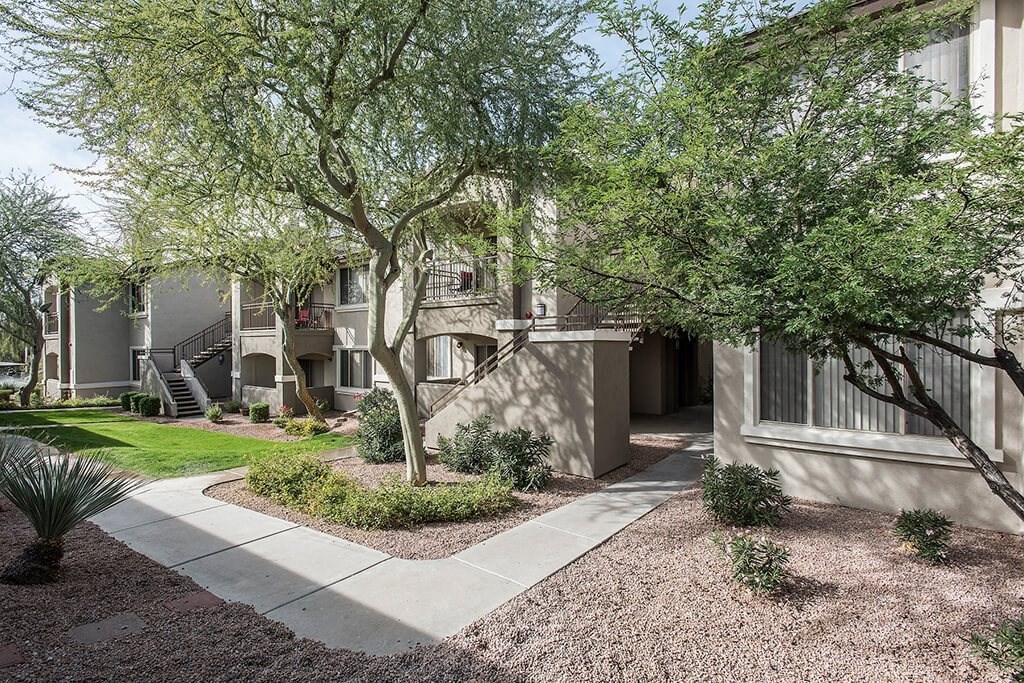 a view of a building with trees and a sidewalk