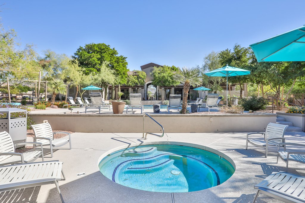 a small pool with chairs and umbrellas at the resort