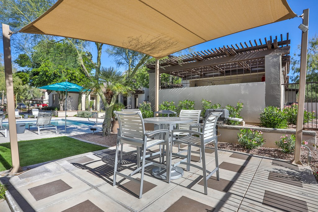 a patio with a table and chairs under a canopy