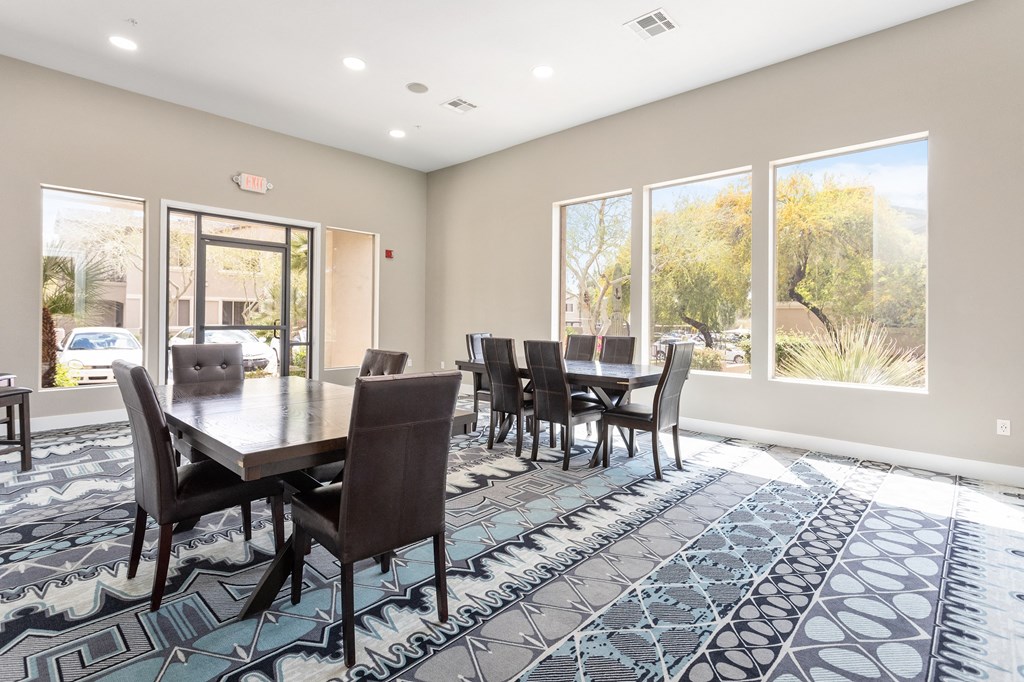 a dining room with a large table and chairs and windows