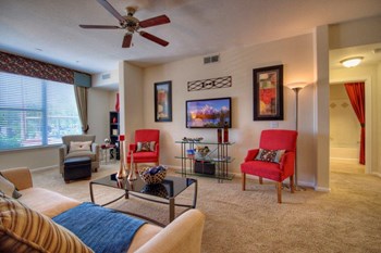 Vue Park West living room with wall to wall carpet, large windows, and ceiling fan - Photo Gallery 16