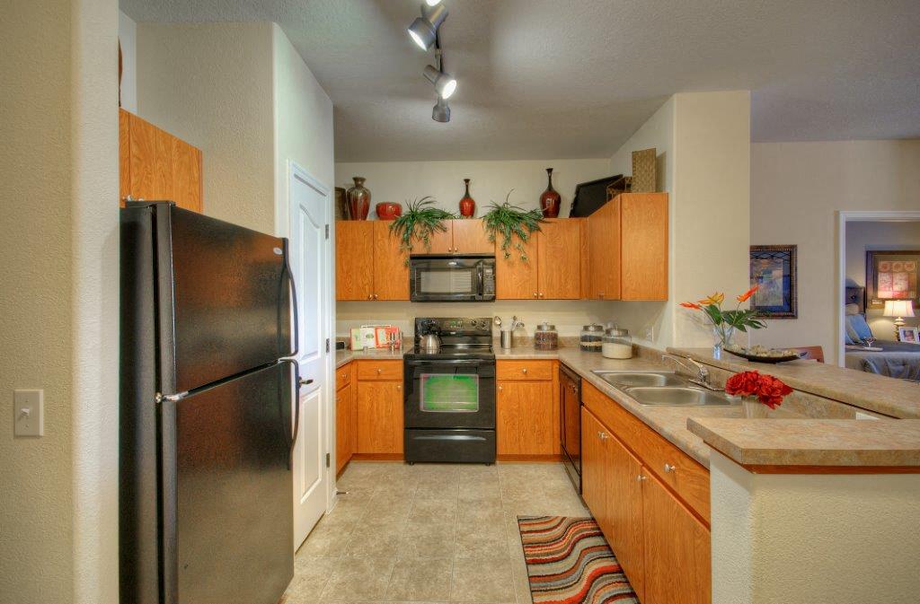 Vue Park West Kitchen with black appliances and brown cabinets