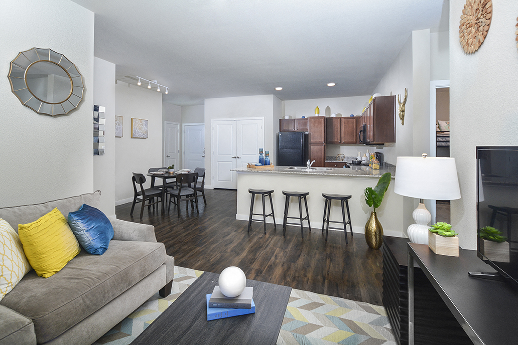 A living room with a grey couch and a wooden floor.