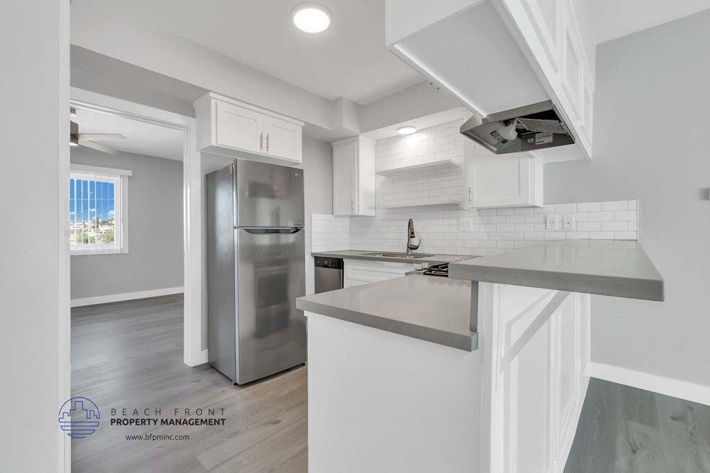 an updated kitchen with stainless steel appliances and white cabinets