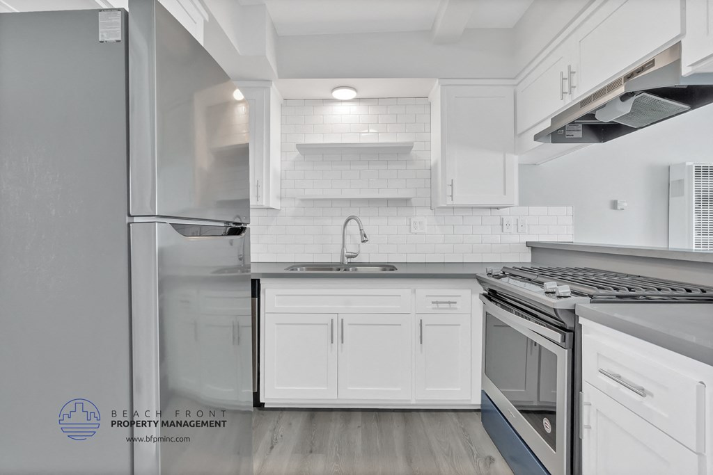 an updated kitchen with white cabinets and stainless steel appliances