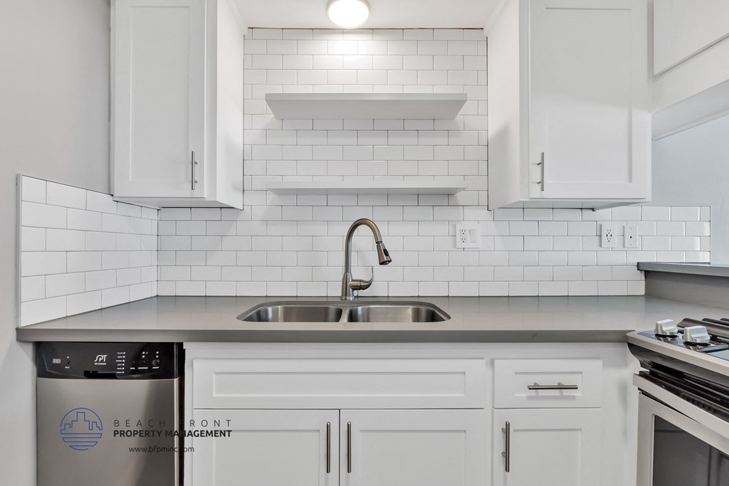 a white kitchen with white cabinets and a sink