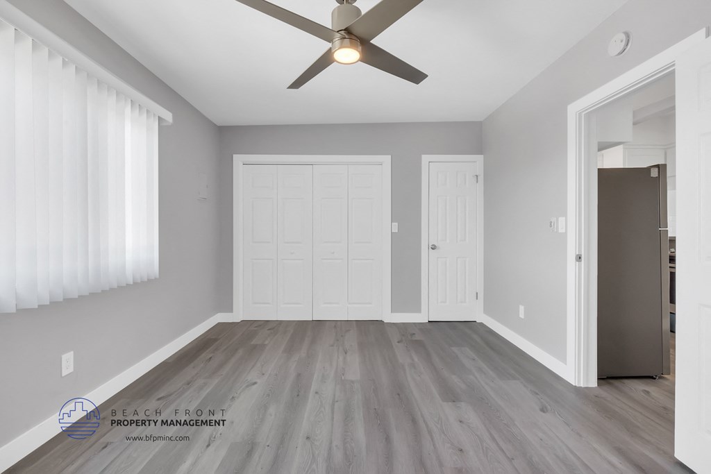 the living room of an empty house with a ceiling fan