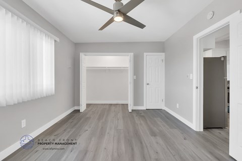 the living room of a new home with white walls and a ceiling fan