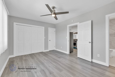 a bedroom with two closets and a ceiling fan