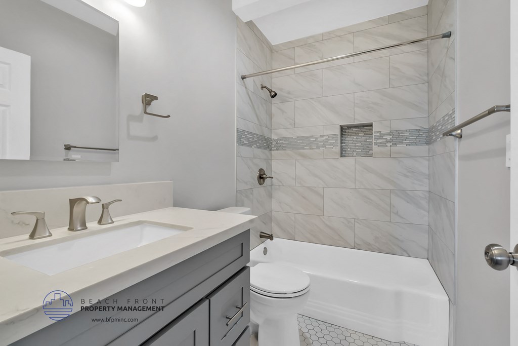 a white bathroom with a tub and a sink and a toilet