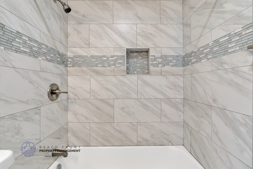 a white and gray bathroom with a shower and a tub