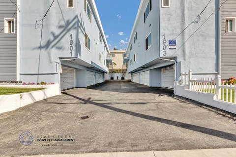an alleyway between two buildings with white units on either side