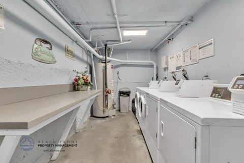 a laundry room with washes and dryers and a counter
