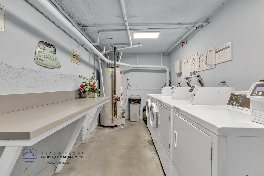 a laundry room with washes and dryers and a counter with a counter top