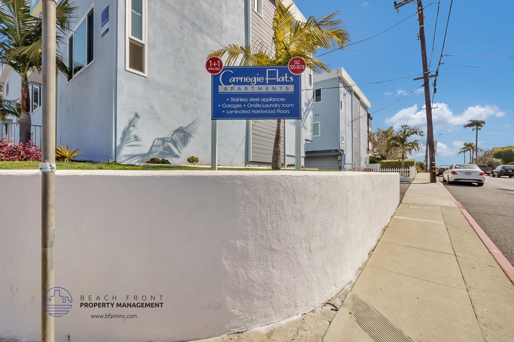 a white wall with a blue sign on the side of a street