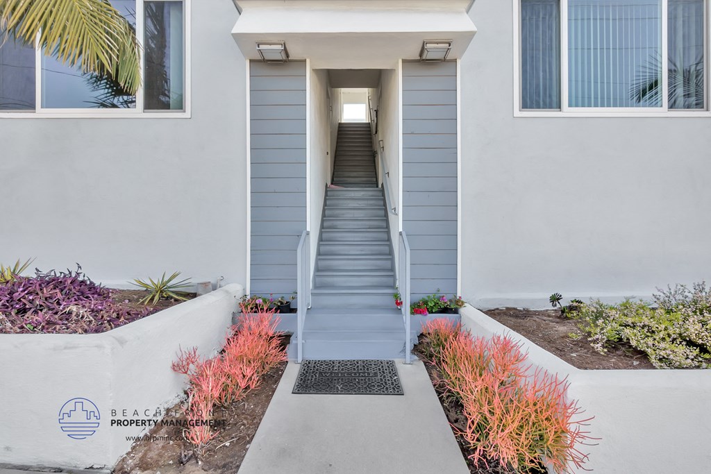 a stairway leading up to a white building with blue steps