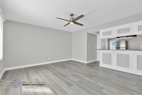 a living room with a ceiling fan and a kitchen