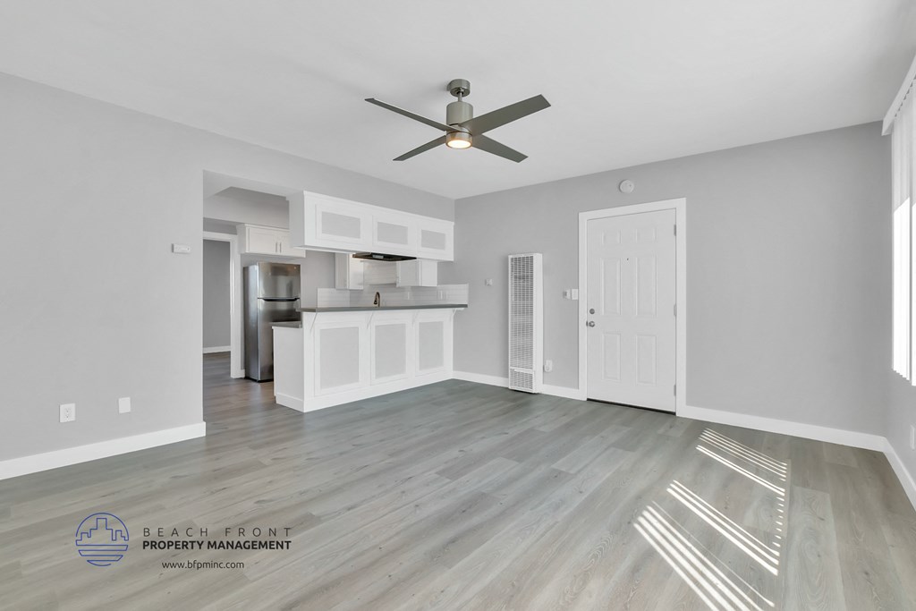 a living room with a ceiling fan and a kitchen