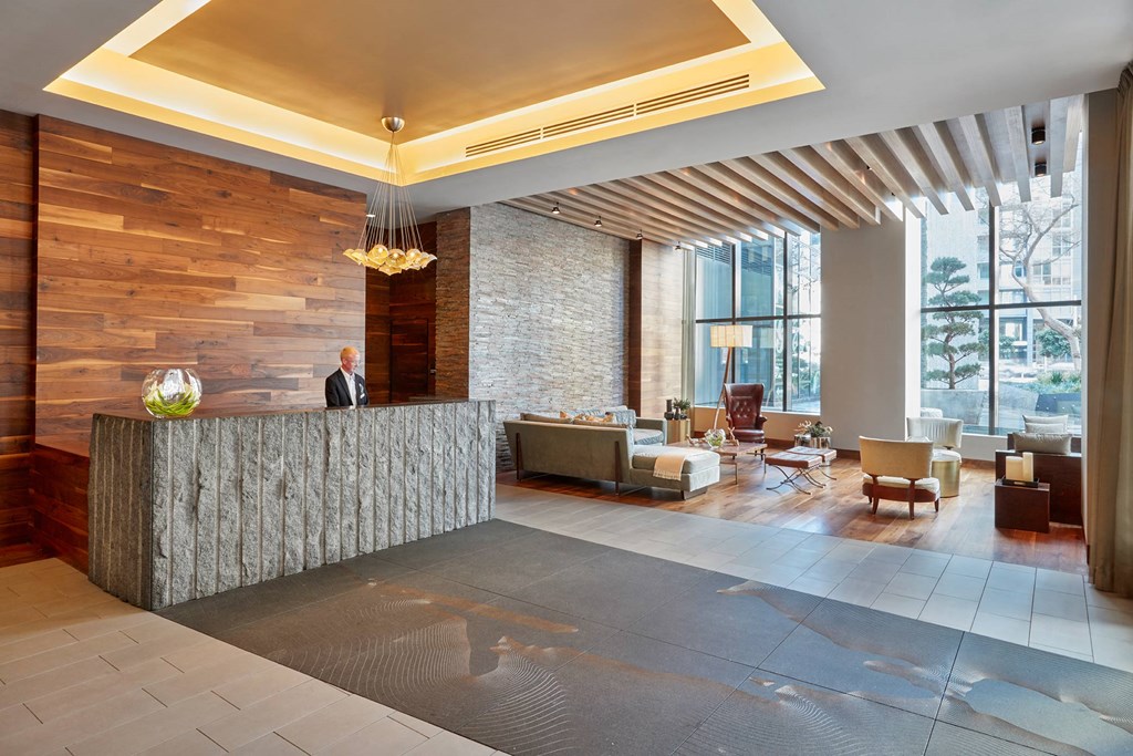 a hotel lobby with a reception desk and large windows