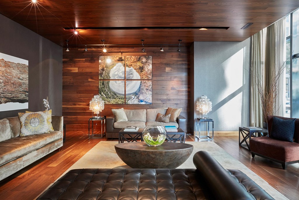 a living room with leather furniture and a large painting on the wall