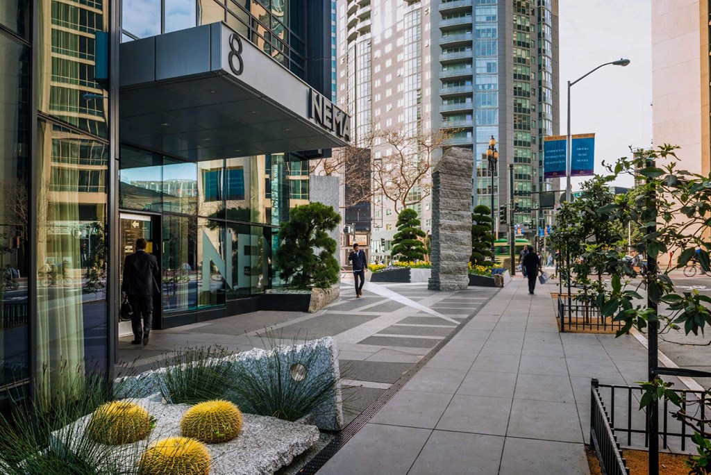 people walking down a sidewalk in front of a building