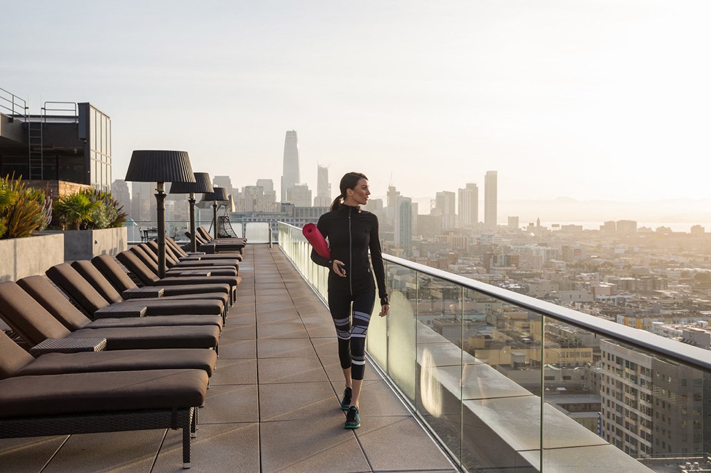 a woman standing on a balcony overlooking the city