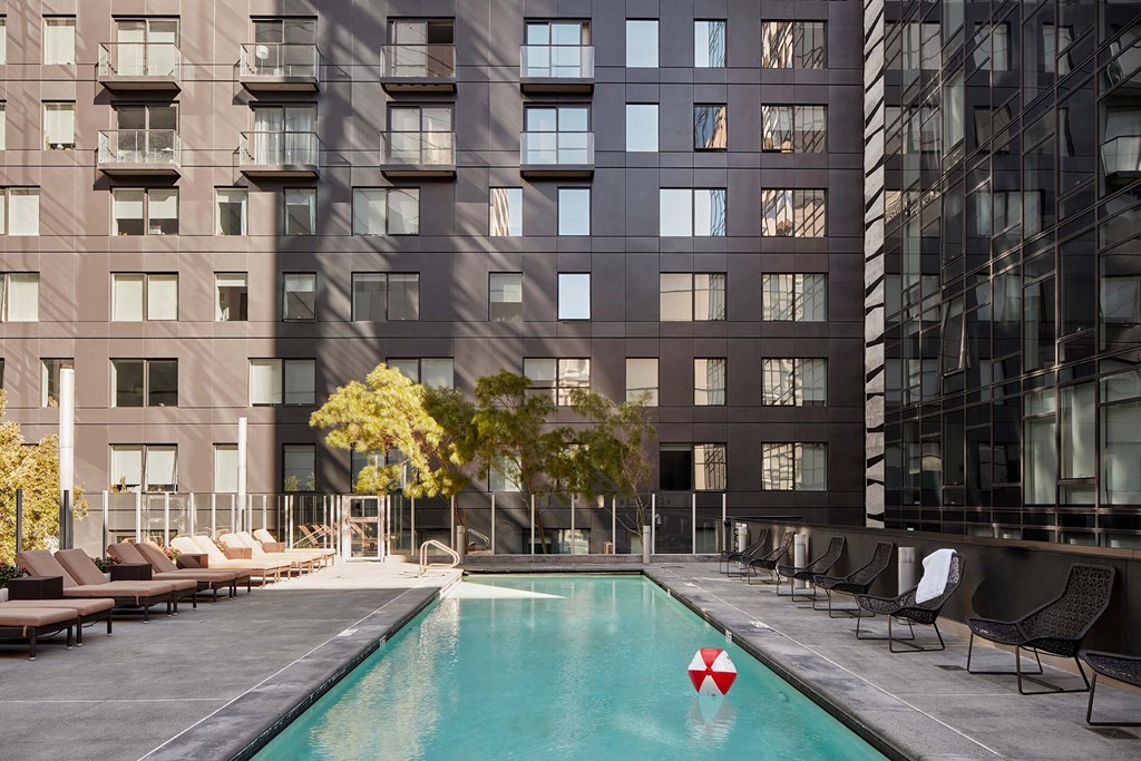 a swimming pool in front of a tall building