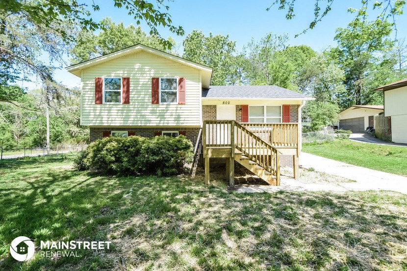 a small house with a porch and a wooden deck