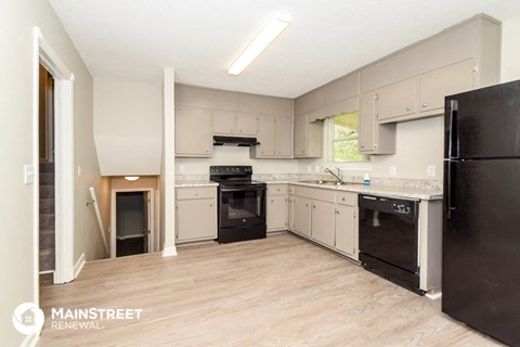 a renovated kitchen with black appliances and white cabinets