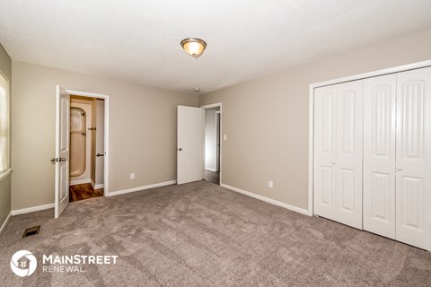 a living room with carpet and two white doors