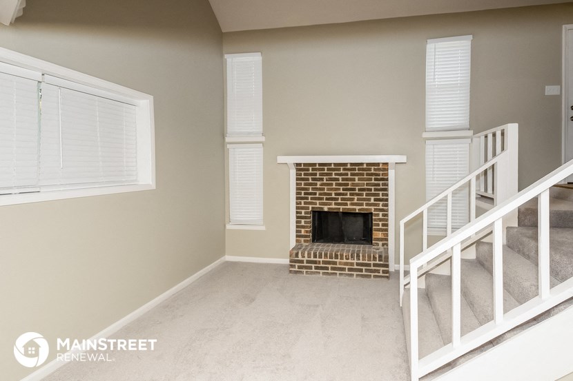 a living room with a fireplace and a staircase
