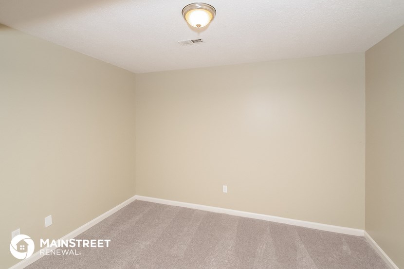 a room with a carpeted floor and a ceiling fan