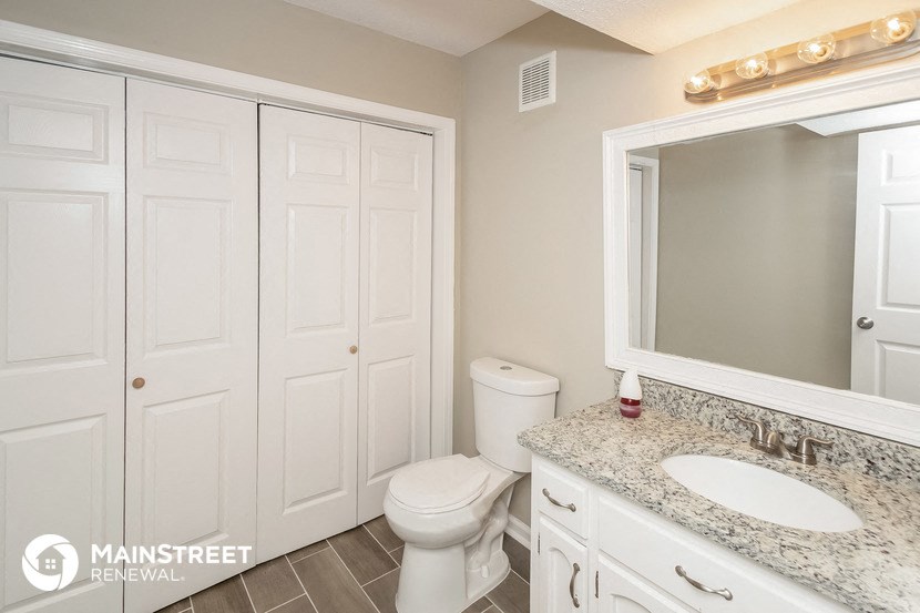 a bathroom with a toilet and a sink and a mirror