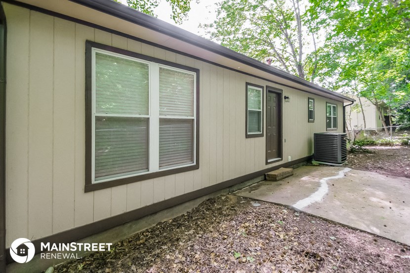 the front of a house with a driveway and a backdoor