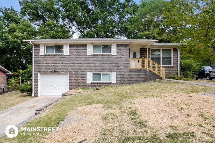 a brick house on a hill with a white garage door