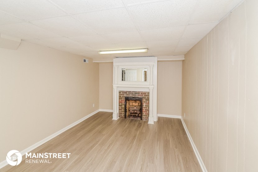 a living room with a fireplace and wooden floors
