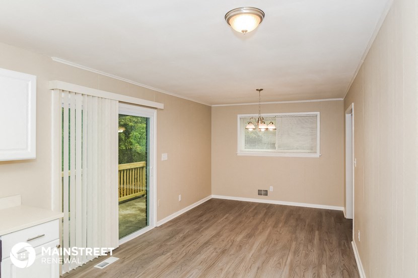 an empty dining room with a sliding glass door to a deck