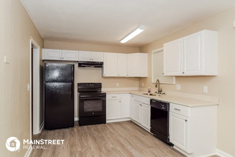 a white kitchen with black appliances and white cabinets